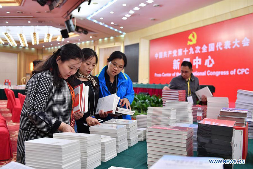 Journalists take books and materials in the press conference hall of the Press Center of the 19th National Congress of the Communist Party of China in Beijing, capital of China, Oct. 11, 2017. The press center based in the Beijing Media Center Hotel began operations on Wednesday. (Xinhua/Li Xin)