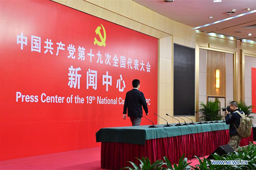 A cameraman (R) takes photos in the press conference hall of the Press Center of the 19th National Congress of the Communist Party of China in Beijing, capital of China, Oct. 11, 2017. The press center based in the Beijing Media Center Hotel began operations on Wednesday. (Xinhua/Li Xin)