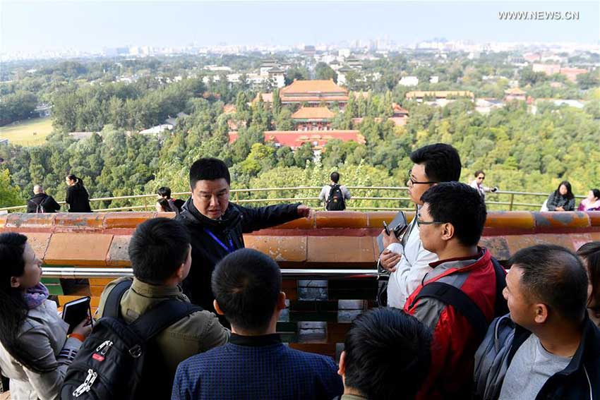 Song Kai (L, 2nd Row), Deputy Director of Jingshan Park, introduces the Central Axis of Beijing to journalists in Beijing, capital of China, Oct. 12, 2017. The Press Center of the 19th National Congress of the Communist Party of China (CPC) organized a reporting tour along the Central Axis of Beijing on Thursday. Chinese and foreign reporters visited scenic attractions such as the Jingshan Park, Yongding Gate and the Olympic Tower. (Xinhua/Li Xin) 