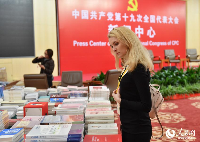 Journalists from China and abroad are attracted by the books displayed at the Press Center of the 19th National Congress of the CPC. The 19th CPC National Congress will convene on Oct. 18 in Beijing. (People's Daily Online Photo / Yu Kai)