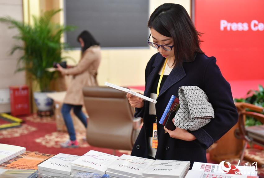 Journalists from China and abroad are attracted by the books displayed at the Press Center of the 19th National Congress of the CPC. The 19th CPC National Congress will convene on Oct. 18 in Beijing. (People's Daily Online Photo / Yu Kai)